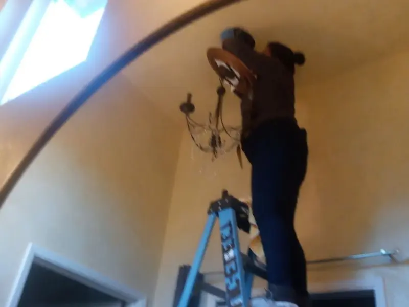 Electrician installing a chandelier in a Clarksville residence